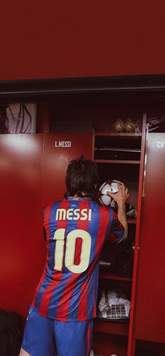 a man in a locker holding a soccer ball