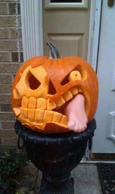 a carved pumpkin with its mouth open on top of a fire hydrant