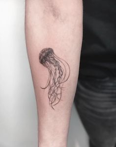 a small black and white jellyfish tattoo on the right forearm