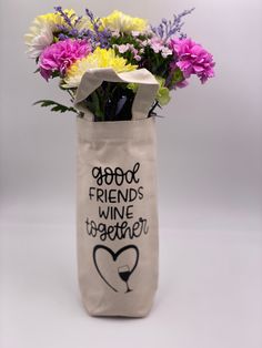 a bag with flowers in it that says good friends wine together