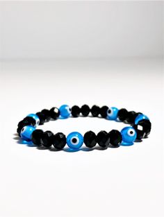 Evil eye bracelet made with black crystals and light blue evil eye beads, all strung together in high quality elastic. Super easy to put on and stack with other bracelets. The light blue evil eye is for general protection from spiritual harm. This eye also helps to bring peace and helps the wearer appreciate the alone time. Evil Eye: 8 mm Product made in USA Receive FREE SHIPPING with your order of $35 or more Light Blue Evil Eye, Jewelry Evil Eye, Kabbalah Bracelet, Bracelet Evil Eye, Evil Eye Beads, Turkish Eye, Red Bracelets, Jewelry Beaded, Protection Bracelet