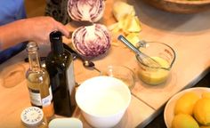 a person is preparing food on a counter with bottles and other foodstuffs in bowls