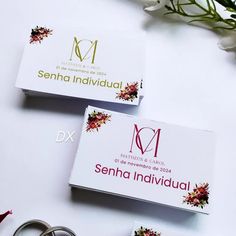 two business cards sitting on top of each other next to some scissors and flower stems