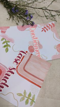 two greeting cards with flowers on them sitting on the ground next to each other,