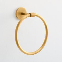 a gold towel ring on a white wall