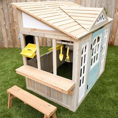 a wooden play house with a picnic table and bench