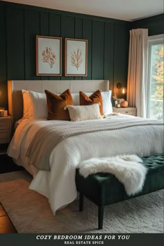 a bedroom with green walls, white bedding and two framed pictures on the wall