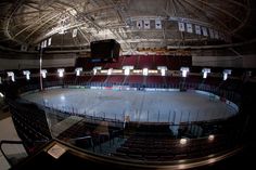 an empty hockey rink with seats and lights