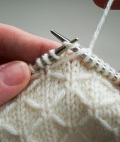 someone is knitting something with their fingers