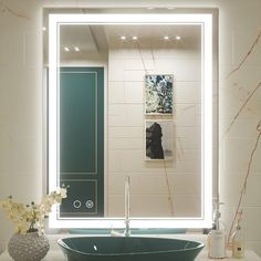 a bathroom sink sitting under a large mirror in front of a wall mounted faucet