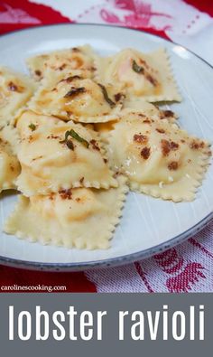 a white plate topped with ravioli on top of a red and white table cloth