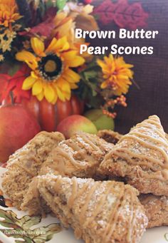 brown butter pear scones on a plate with fall flowers and pumpkins in the background