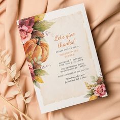 an orange and pink floral thanksgiving party card on a peach colored background with gold foil