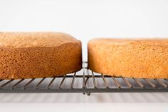 two bundt cakes sitting on top of a metal cooling rack next to each other