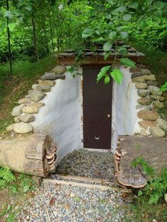 an outhouse in the woods with two benches