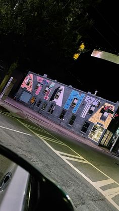 an empty street at night with buildings painted on the side