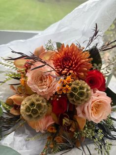 a bouquet of flowers sitting on top of a white sheet