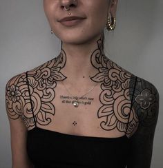 a woman with tattoos on her neck and chest is looking at the camera while wearing a black dress