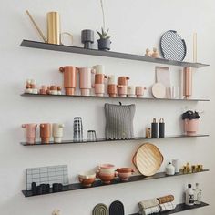 three shelves filled with different types of vases and other items on top of them