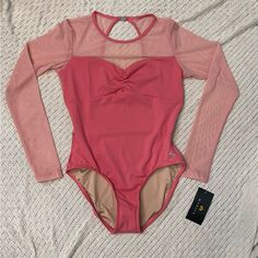 a women's pink bodysuit laying on top of a bed