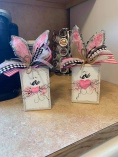 two small bags with bows on them sitting on a counter top next to a blender