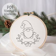 a cross stitch christmas ornament with a santa hat and beard