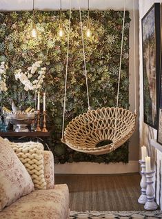 a living room filled with furniture next to a wall covered in plants and greenery