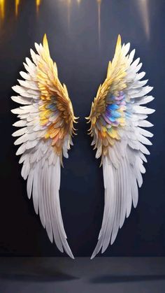 two white and yellow wings on a black background with lights in the backround