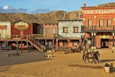 an old western town with horses and buildings