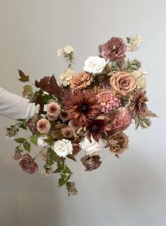 a woman holding a bouquet of flowers in her hand