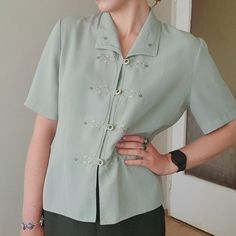 Pretty mint green vintage button down blouse with delicate embroidery details in great condition. Material assumingly chiffon blend, fabric is non crinkly, very light and slightly see through. Will fit S-L,  Measurements laid flat : Bust 50 cm / 19" Waist 45 cm / 17" Sleeve lenght 27 cm /10" Total lenght 60 cm / 23"  My height is 1.70 m/ 5"7 Spring Blouse With Buttons And Collared Neckline, Green Collared Shirt For Spring, Green Short Sleeve Tops With Button Closure, Green Short Sleeve Top With Button Closure, Elegant Green Spring Shirt, Elegant Green Shirt For Spring, Spring Formal Shirt With Collared Neckline, Green Embroidered Collared Shirt, Collared Shirt With Buttons For Spring