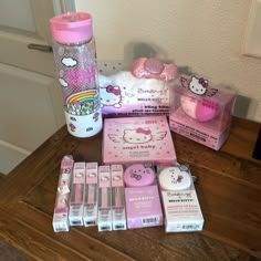 hello kitty products are displayed on a wooden table with a pink bottle and other items