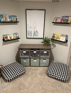 a room with two dog beds and some books on the shelves above them, in front of a poster