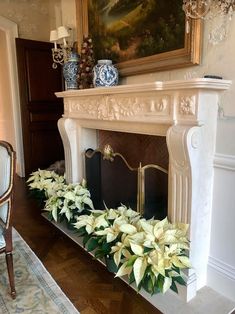 the fireplace is decorated with white flowers and greenery