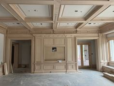 an empty room with wooden paneling on the ceiling and windows in the back ground