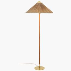 a floor lamp with a beige shade on it