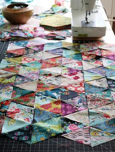 a table topped with lots of different types of quilts and sewing machines on top of it