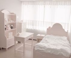 a bedroom with white furniture and curtains on the windowsill, along with a small bed