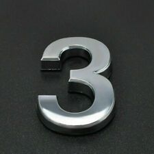 the number three is made out of metal on a black surface with a white background