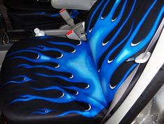 the interior of a car with blue and black flames on it's seat covers