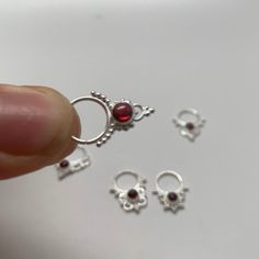 These are soooooo pretty. Made is 925 sterling silver with tribal details, set with a deep red garnet stone. The rings are all 1cm (.40”) in diameter. The wire is 20 gauge.Stones shine light through them since the back is open. Hard to see this when they are lying flat.One of the images contains numbers to specify which you would like from the drop down menu. Silver Goddess, Grass Valley, Septum Piercing, Nose Rings, Nose Ring Stud, Garnet Stone, Sterling Silver Flowers, Garnet Gemstone, Red Garnet