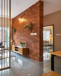 a living room with a brick wall and glass doors