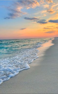 the sun is setting at the beach with waves coming in