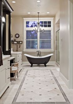 a large bathroom with a claw foot tub and chandelier