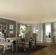 a dining room table and chairs in front of a brick wall with doors leading to the outside