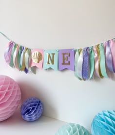 there is a one sign on the wall next to tissue balls and paper decorations in pastel colors