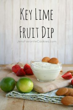 the ingredients for key lime fruit dip sit on a cutting board next to strawberries and limes