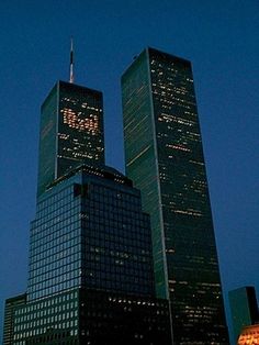 two very tall buildings in the city at night