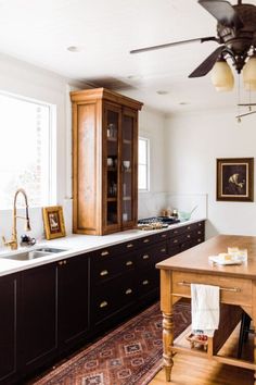 a kitchen with an island, sink and cupboards in the middle of the room