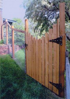 a wooden fence with two black latches on the top and bottom bars attached to it